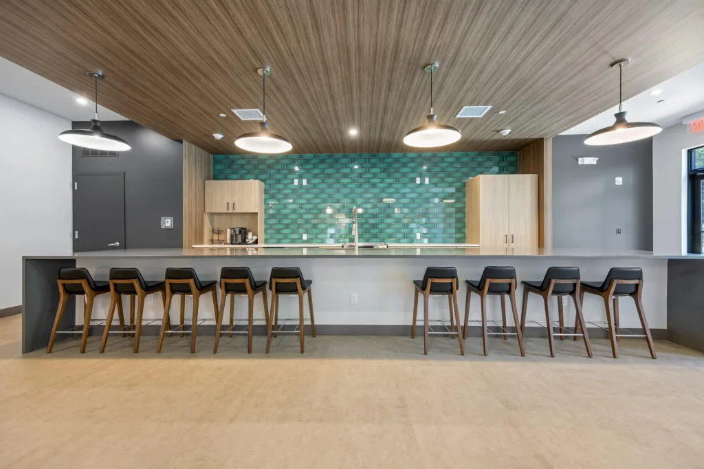 The Beacon clubhouse community kitchen area with extra long bar top counter and bar stool seating