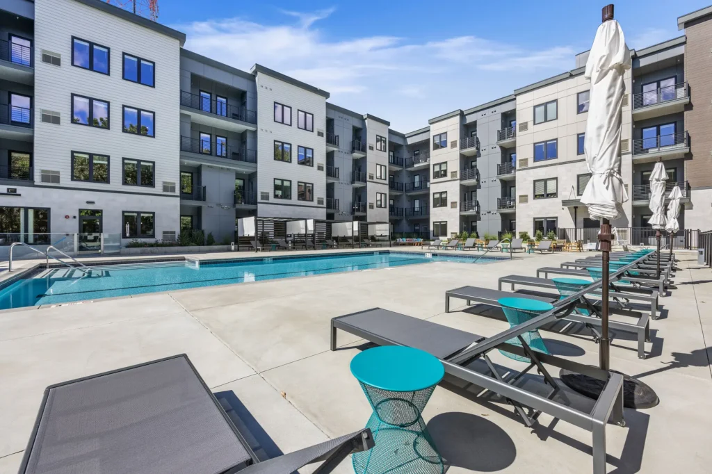 The Beacon swimming pool courtyard with chaise lounge chairs, shade umbrellas, and cabanas